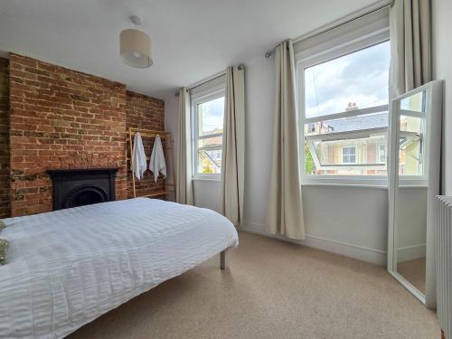 ein Schlafzimmer mit einem Bett und einer Ziegelwand in der Unterkunft Cosy Cottage in Broadstairs in Broadstairs