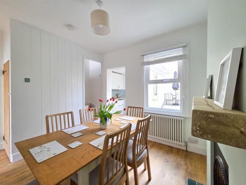 a dining room with a wooden table and chairs at Cosy Cottage in Broadstairs in Broadstairs