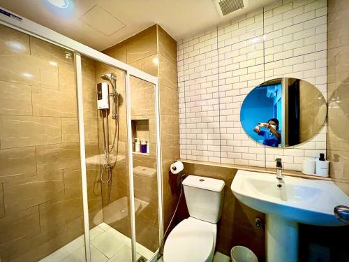 a bathroom with a toilet and a sink and a mirror at The Circle 4 in Bangkok