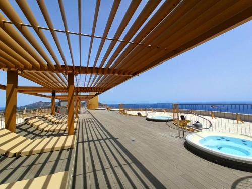 a patio with a hot tub and a deck with chairs at Intempo Sea Views by Agencia Poniente in Benidorm