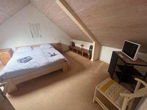 une chambre mansardée avec un lit et un bureau dans l'établissement PENTY DU BELOU, cozy, en pleine campagne, 1 à 6 personnes, à Mellac