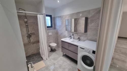 La salle de bains est pourvue d'un lavabo et d'un lave-linge. dans l'établissement Villa familliale Mornas 4 chambres, à Mornas