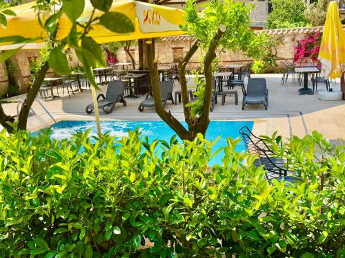 a swimming pool with chairs and tables and a umbrella at Necip Bey Konağı in Antalya