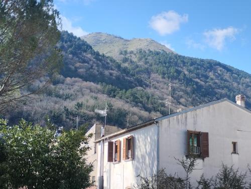 a white building with a mountain in the background at Molise Garden Apartments Renato in Boiano