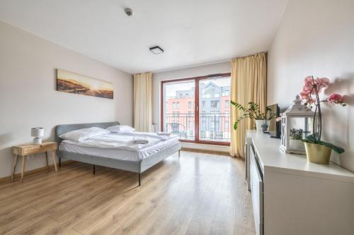 a bedroom with a bed and a large window at Grand Apartments - Apartments SPA Waterlane Island in Gdańsk