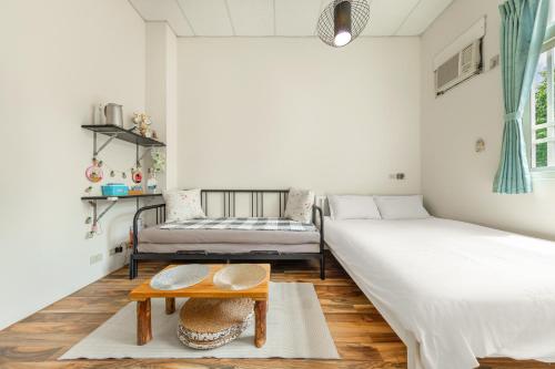 a room with two beds and a table in it at 山水桃米旅店 in Puli
