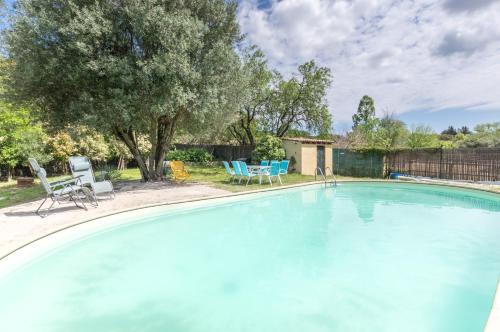 une grande piscine avec deux chaises et une table dans l'établissement Maison avec piscine location de vacances ferme pédagogique du dolmen, à Le Pouget