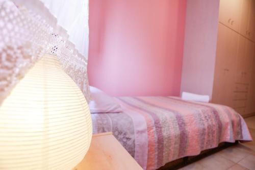 a bedroom with a bed and a lamp on a table at Marousa's Country House 12 minutes from Athens Airport in Koropíon