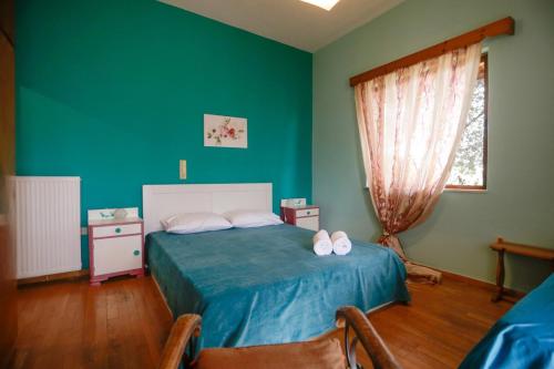 a bedroom with a bed and a green wall at Marousa's Country House 12 minutes from Athens Airport in Koropíon