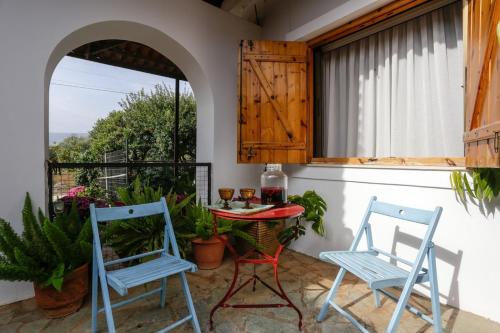 two blue chairs and a table on a patio at Marousa's Country House 12 minutes from Athens Airport in Koropíon
