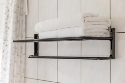 a stack of towels on a shelf in a bathroom at 山水桃米旅店 in Puli