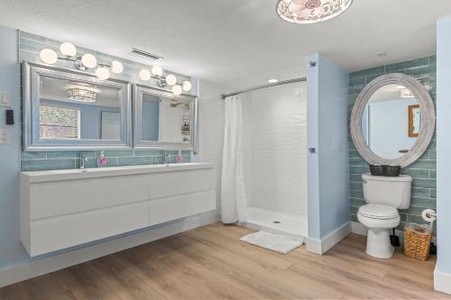 Un baño con lavabo, inodoro y espejo. en Snook Haven, en Clearwater Beach