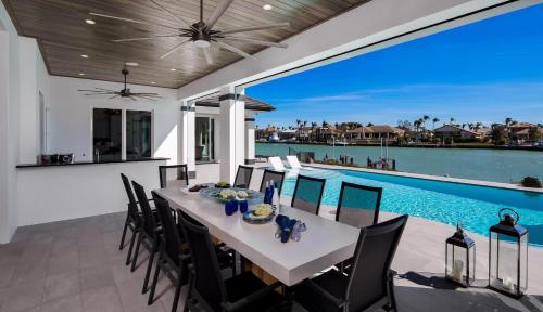 a dining room with a table and chairs and a swimming pool at Meridian Blu in Marco Island