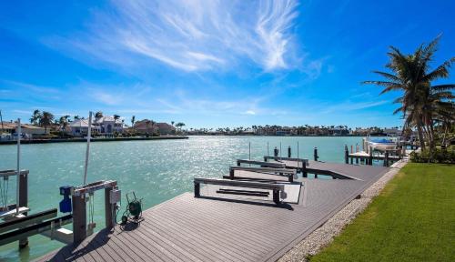 a row of benches on a dock next to the water at Meridian Blu in Marco Island