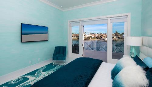 a bedroom with a bed and a tv and a balcony at Meridian Blu in Marco Island