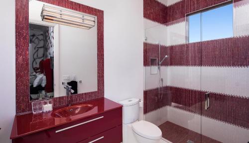 a bathroom with a toilet and a sink and a mirror at Meridian Blu in Marco Island