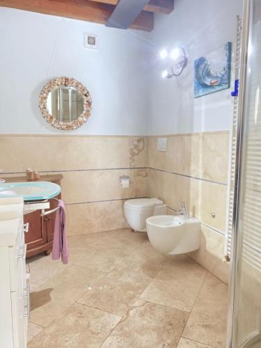 a bathroom with a sink and a toilet and a mirror at Wohnung Mit Privatem Garten Und Schöner Aussicht in Moniga