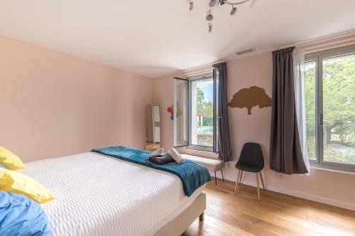 une chambre avec un lit et deux fenêtres dans l'établissement Maison avec piscine location de vacances ferme pédagogique du dolmen, à Le Pouget