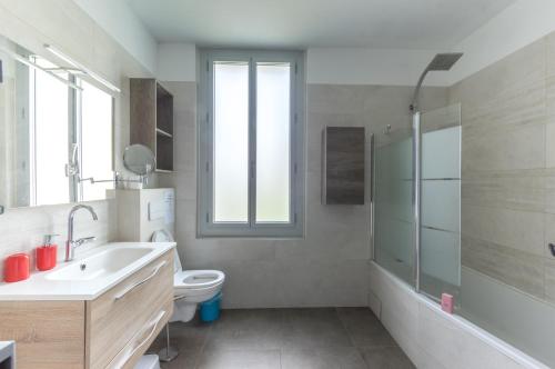 une salle de bain avec un lavabo et des toilettes et une fenêtre dans l'établissement Maison avec piscine location de vacances ferme pédagogique du dolmen, à Le Pouget