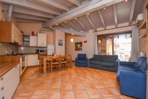 a kitchen and living room with a table and chairs at Wohnung Mit Privatem Garten Und Schöner Aussicht in Moniga