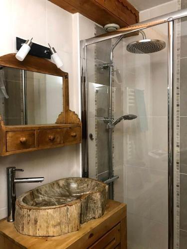 La salle de bains est pourvue d'un lavabo en bois et d'une douche. dans l'établissement Cosy alpine apartment with pool and stunning views, à Saint-Gervais-les-Bains