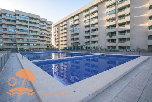 een zwembad voor sommige appartementsgebouwen bij Front Sun Beach Apartment in Valencia