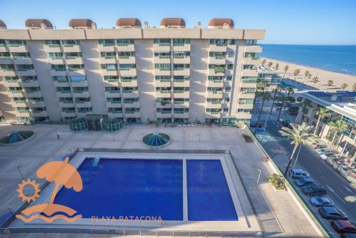 een groot gebouw met een zwembad naast het strand bij Front Sun Beach Apartment in Valencia