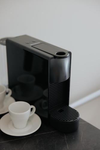 a black microwave with a cup of coffee on a table at Odysseia Hotel Kapetanios in Limassol