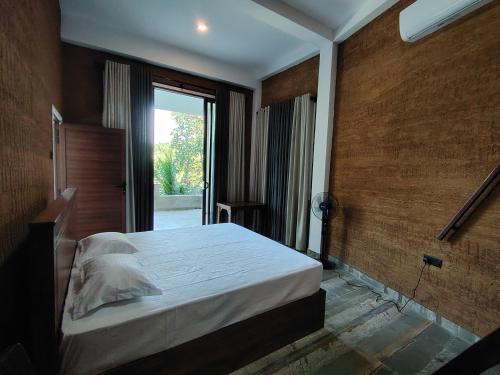 a bedroom with a bed and a large window at Star Guest in Balangoda