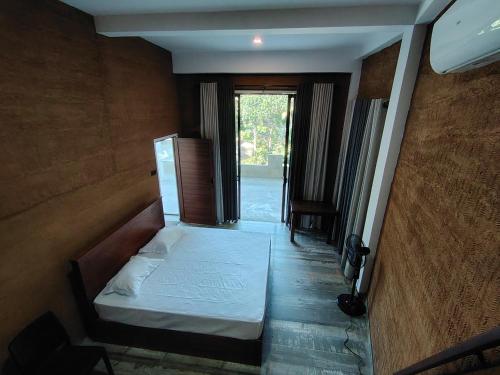 a bedroom with a bed in a room with a hallway at Star Guest in Balangoda