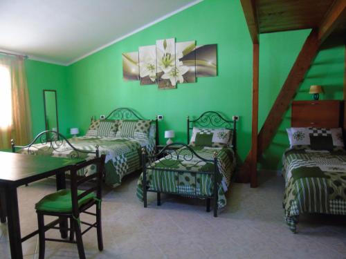 una stanza verde con tre letti e un tavolo di Casa da Pina a Càbras