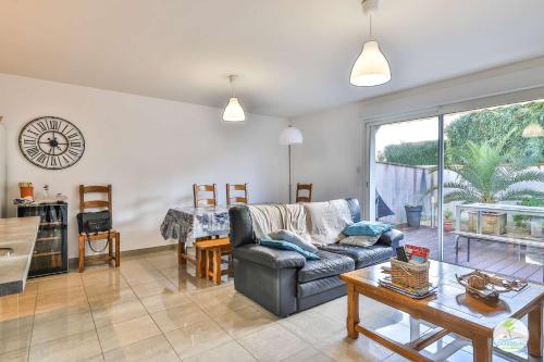 un salon avec un canapé et une table dans l'établissement Biscarrosse Maison 6 couchages avec terrasse, à Biscarrosse