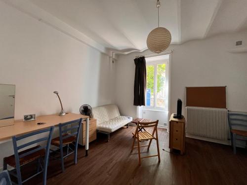 un salon avec une table, des chaises et un canapé dans l'établissement Studio PMR proche du centre, à Clermont-Ferrand