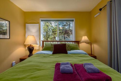 a bedroom with a green bed with two pillows on it at Moose Manor in Packwood