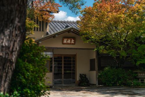 a house with a garage and a tree at Monjusou Shourotei in Miyazu