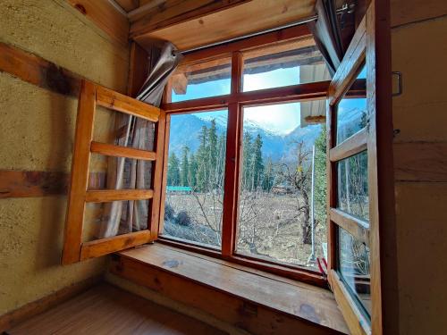 a window in a room with a view of a mountain at Yalakhom Homestay in Kulu