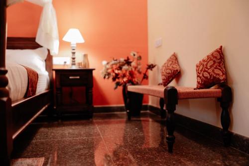 a bedroom with a bed and a table with a vase of flowers at Adhyaya - Heritage Reverbed 4 BHK AC Triplex Villa in Vānivilāsa Puram