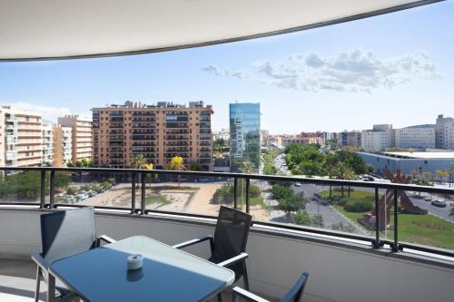 a balcony with a table and chairs and a view of a city at Maya Bay Suites in Alicante