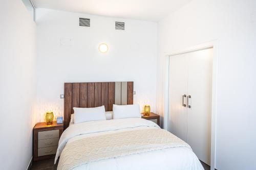 a bedroom with a large bed with a wooden headboard at Maya Bay Suites in Alicante