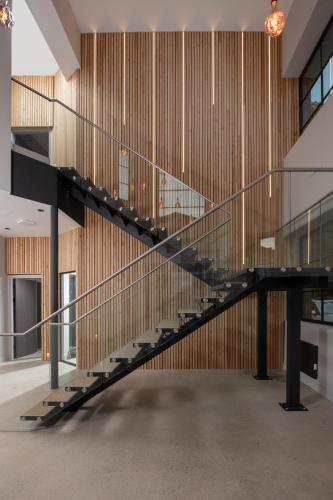 a glass staircase in a building with wooden walls at Montgomery House Apart-Hotel in Headingley