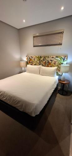 a bedroom with a large bed with white sheets at Zimbali Suites 317 - 1 bedroom in Ballito