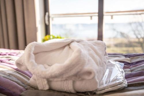 a pile of towels on a bed with a window at Smygehus Havsbad in Smygehamn