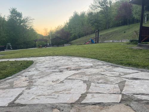 a stone walkway with a park in the background at Kuca za odmor Marjanovic in Gornji Milanovac