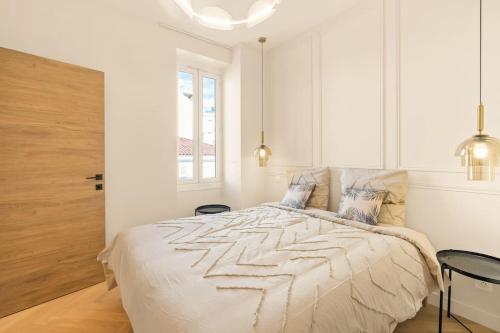 une chambre blanche avec un lit et une fenêtre dans l'établissement Avenue Chic, à Cannes
