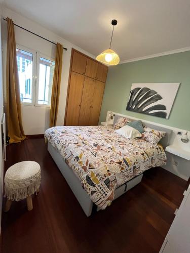 a bedroom with a bed with a comforter on it at Surf Nest in Machico