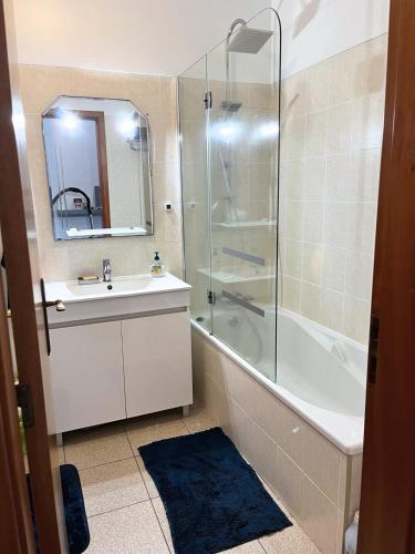 a bathroom with a shower and a sink and a mirror at Surf Nest in Machico