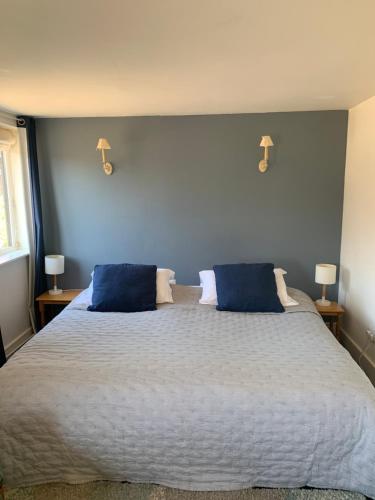 a bedroom with a large bed with two blue pillows at Bluebell Barn in Banham