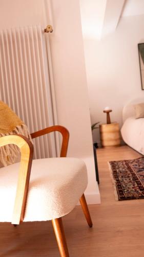 a chair sitting in a room with a bed at Le Mercœur - studio cosy - hyper centre Nantes in Nantes