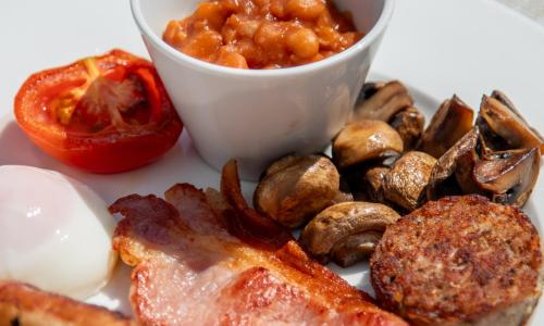 a plate of food with meat and mushrooms and a cup of sauce at Mevagissey Bay Hotel in Mevagissey