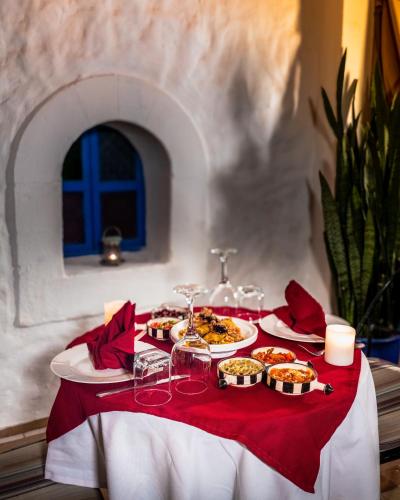 a table with plates of food on a red table cloth at Riad Al Madina in Essaouira